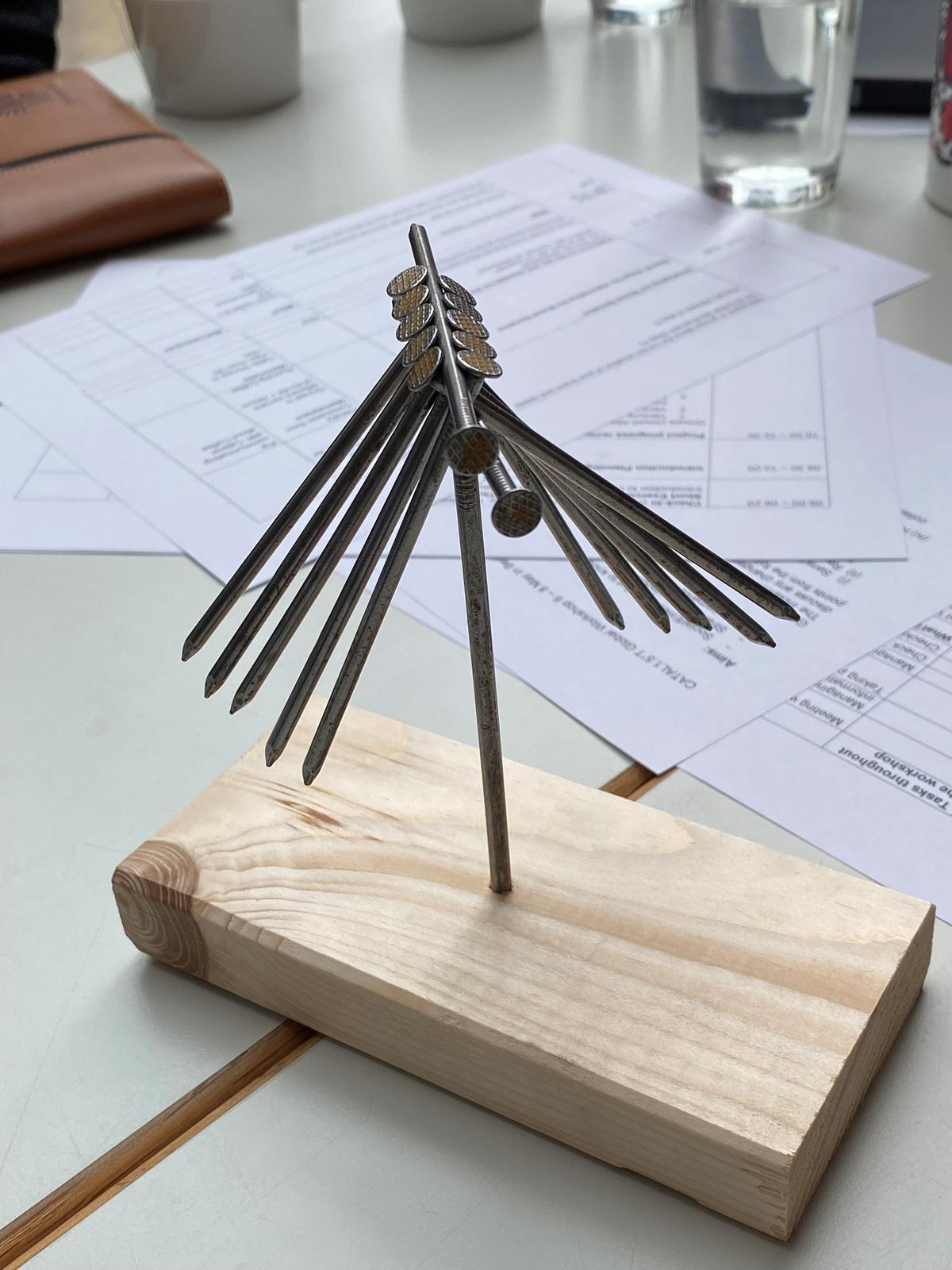 pieces of nails delicately balance on a single nail as part of a design thinking game during the CATAL1.5°T Initiative Global  Workshop